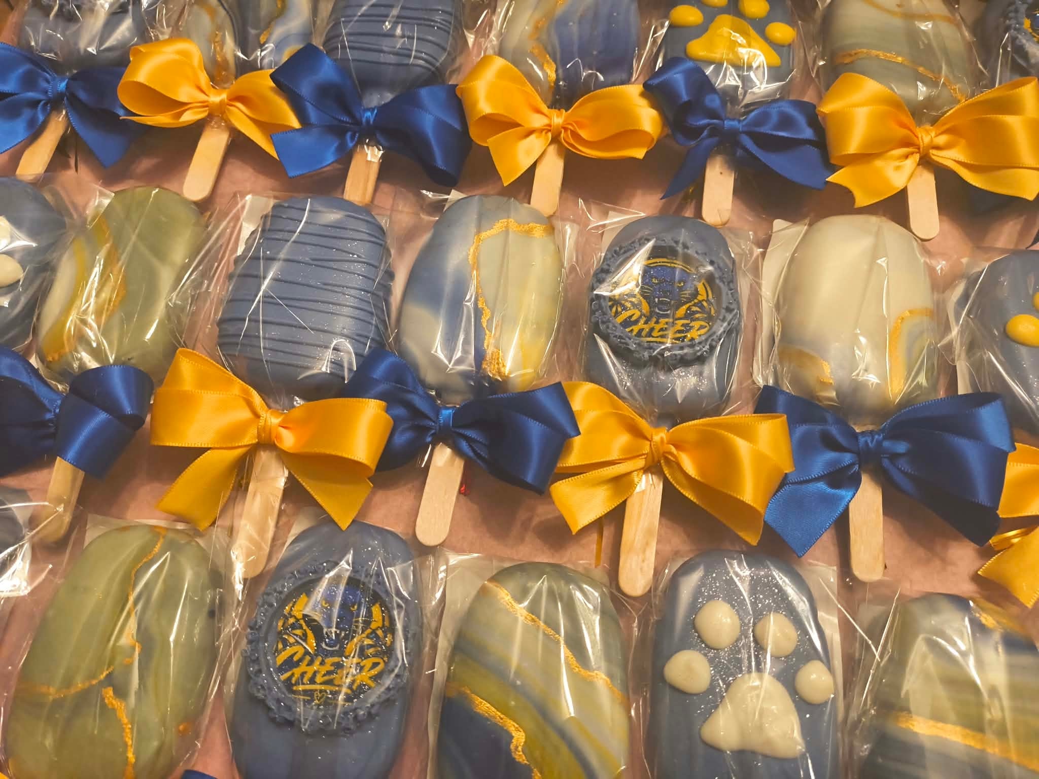 Chocolate lollipops with blue and gold ribbon bows